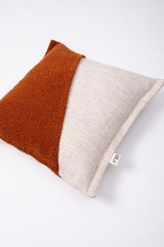 a brown and white pillow on a white surface