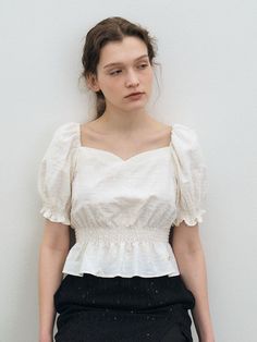 This product features a puff sleeve smock crop blouse, offering a delicate and romantic look with its floral texture. The sweetheart neckline and cropped smock design enhance its feminine appeal, making it a charming addition to any outfit. Ideal for layering or wearing alone on warmer days, this blouse pairs beautifully with both skirts and high-waisted pants. - The blouse boasts puff sleeves that add a dramatic and stylish touch to the overall design.- A sweetheart neckline frames the face and neck beautifully, contributing to the garment's elegance.- Its cropped length and smocked bodice ensure a comfortable and flattering fit for various body types.- The subtle floral texture adds a hint of sophistication and depth to the fabric, elevating the simple silhouette. Elegant Top With Smocked Back And Square Neck, Elegant Tops With Smocked Back And Square Neck, Elegant Spring Smocked Top With Puff Sleeves, Elegant Puff Sleeve Top With Smocked Bodice For Spring, Elegant Puff Sleeve Smocked Top For Spring, Feminine Smocked Top With Square Neck, Elegant Smocked Top With Puff Sleeves And Ruffles, Elegant Smocked Top With Ruffles And Puff Sleeves, Elegant Summer Puff Sleeve Top With Smocked Back