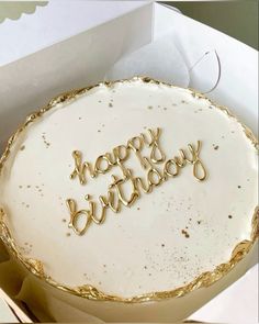 a birthday cake with the words happy birthday written on it in gold foil and white frosting