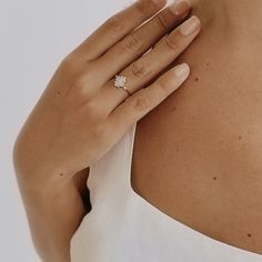 a woman's hand with a diamond ring on her shoulder