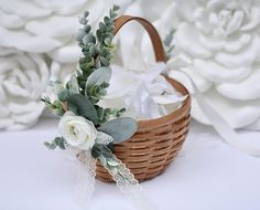 a basket filled with white flowers and greenery