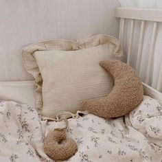 a teddy bear laying on top of a bed next to a pillow and stuffed animal