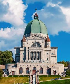 a large building with a green dome on top and stairs leading up to the entrance