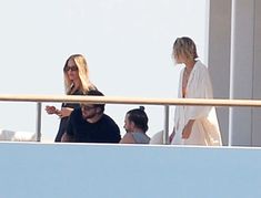 two women and a man on a balcony