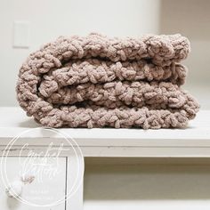 a stack of towels sitting on top of a white dresser