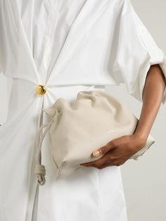 According to our buyers, slouchy bags are one of this season's most sought after styles and Loewe's understated 'Flamenco' clutch is the perfect way to tap into the trend. Crafted in Spain from supple leather and lined in suede, it's detailed with knotted drawstring ties to create a scrunched top and embossed with the label's 'Anagram' logo. Carry yours under the crook of your arm or attach the optional strap. Designer Clutch Pouch For Everyday, Designer Everyday Clutch Pouch, Designer Everyday Pouch Clutch, Designer Soft Leather Pouch Clutch, Luxury Beige Everyday Pouch, Everyday Luxury Leather Clutch, Designer White Leather Clutch, Everyday Clutch With Dust Bag Included, Elegant Beige Leather Pouch