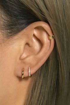 a close up of a person's ear with two gold rings