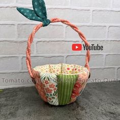 a basket that is sitting on top of a cement surface with a bow in it