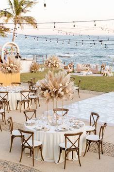 an outdoor dining area with tables and chairs set up for a formal function at the beach