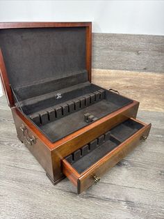 an open briefcase sitting on top of a wooden floor next to another box filled with keys