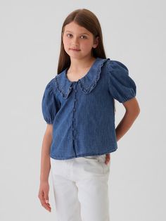 Kids Ruffle Collar Denim Shirt | Gap Gap Ruffled Short Sleeve Tops, Short Sleeve Denim Top With Ruffles, Denim Blue Ruffled Short Sleeve Top, Denim Blue Short Sleeve Top With Ruffles, Ruffled Short Sleeve Denim Top, Denim Ruffled Short Sleeve Tops, Short Sleeve Washed Blue Cotton Blouse, Washed Blue Cotton Short Sleeve Blouse, Medium Wash Cotton Puff Sleeve Top