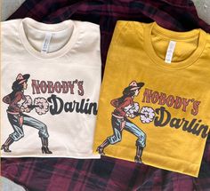 Nobody's Darlin Short Sleeve Tee graphic tee - dropship thelattimoreclaim Retro Fall Rodeo T-shirt, Fitted T-shirt For Rodeo In Fall, Pre-shrunk Tops For Rodeo In Fall, Hippie Tshirt, Country Tees, Western Graphic Tees, Vintage Country, Soft Shorts, Disney Outfits