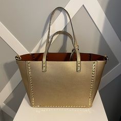 Brand New, Trendy Studded Tote. It’s Soft Vegan Leather And It’s Super Cute! It Comes With A Pouch, And Strap. It Will Be Coming From A Pet/Smoke Free Home. Gold Shoulder Bag With Branded Hardware And Double Handle, Gold Bags With Branded Hardware And Double Handle, Gold Satchel Bag With Branded Hardware, Shopping Bags With Metal Hardware In Tote Shape, Gold Leather Bags With Branded Hardware, Luxury Gold Bag For Errands, Gold Tote Bag For Shopping, Gold Shoulder Bag With Branded Hardware, Gold Bags With Metal Hardware For Daily Use