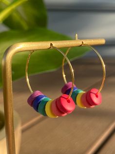 Handmade Mini Beaded Polymer Clay Hoop Earrings These hoop earrings feature rainbow-colored textured handmade mini beads strung on the hoop. Show your pride all year long in these bright, lightweight hoops. There are a total of seven beads on each hoop earring. The diameter of the beads is roughly 9mm. The 25mm hoop is the perfect size for those on the go. These earrings come in both gold and rhodium-plated brass which is nickel-free. Wear these to work, a date, a night out, or wherever you want. All my earrings are cut, baked, and assembled with love from Pennsylvania. Rainbow Dangle Hoop Earrings, Rainbow Hoop Earrings With Colorful Beads, Rainbow Small Hoop Earrings With Colorful Beads, Rainbow Colorful Beads Hoop Earrings, Rainbow Round Hoop Earrings With Colorful Beads, Rainbow Beaded Small Hoop Earrings For Gift, Rainbow Hoop Earrings With Ear Wire, Handmade Rainbow Hoop Earrings, Adjustable Rainbow Small Hoop Earrings