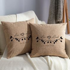 two pillows that are sitting on top of a couch with the words, love is in the air