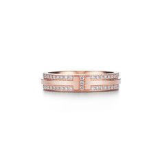 Scintillating diamonds trace the bold form of the letter "T" in this striking design. As multifaceted as it is iconic, the Tiffany T collection is a tangible reminder of the connections we feel but can't always see. Pair this brilliant design with a Tiffany diamond bracelet for a refined look. 18k rose gold with pavé diamonds; 4.5 mm wide; Carat total weight .45 | Tiffany T Narrow Pavé Diamond Ring in 18k Rose Gold, 4.5 mm Wide, Size: 6 Face Dermal Piercing, Tiffany Co Rings, The Letter T, Jean Schlumberger, Tiffany Rings, Engagement Rings Couple, Tiffany Diamond, Tooth Gems, Tiffany T