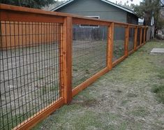 the fence is made of wood and has metal bars on each side, along with grass