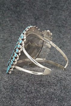 This stunning turquoise and sterling silver bracelet was made by Zuni silversmith Merlinda Chavez. The inside is signed D & M Chavez and Zuni.Size: 5 1/2" (will fit up to a 6 3/4" wrist)Gap: 1 1/4"Width: 2"Free shipping on all orders! We ship with USPS and always include tracking. All orders ship within a day of payment.Returns are accepted up to 30 days after you receive your order. Just send us a message. Our shop offers cash back or store credit. The item must be returned in new condition. Turquoise Bangle For Formal Occasions, Formal Turquoise Bangle Jewelry, Unique Turquoise Jewelry With Polished Finish, Artisan Turquoise Jewelry For Formal Occasions, Elegant Sterling Silver Bracelet With Turquoise, Elegant Turquoise Bracelet With Inlay, Elegant Turquoise Inlay Bracelet, Silver Southwestern Style Cuff Bracelet For Formal Occasions, Unique Turquoise Sterling Silver Bracelets