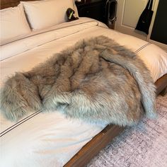 a bed with a fur blanket on top of it