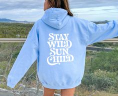 Stay Wild Sun Child - Summer Oversized Retro Hoodie Order 1-2 sizes larger for an oversized fit. Design on front (small) and back (large). This unisex heavy blend hooded sweatshirt is relaxation itself. Made with a thick blend of cotton and polyester, it feels plush, soft and warm, a perfect choice for any cold day. In the front, the spacious kangaroo pocket adds daily practicality while the hood's drawstring is the same color as the base sweater for extra style points. .: 50% cotton, 50% polyes Oversized Casual Hoodie For Outdoor, Casual Oversized Outdoor Hoodie, Oversized Cotton Hoodie For Outdoor, Outdoor Blue Sweatshirt With Letter Print, Casual Outdoor Hoodie With Letter Print, Casual Hoodie With Letter Print For Outdoor, Casual Letter Print Hoodie For Outdoor, Oversized Letter Print Casual Hoodie, Oversized Casual Hoodie With Letter Print