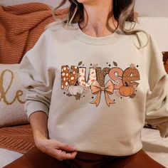 Fall Nurse Sweatshirt, Nurse Pumpkin Sweat, Gift for Nurse, Fall Coquette Bow Sweat, Gift for Registered Nurse, Retro Nurse Sweater Welcome to NoordesignBySelin!🌟 Thank you for visiting our shop! We hope you find something that adds a little extra warmth and beauty to your day. 😊 Happy Shopping! 🛒 📢 Important Details: Check All Photos: Review all images for product details. 📸 Choose Size & Color: Select your T-shirt size from the drop-down list next to the item picture. For color options, r Nurse Pumpkin, Fall Coquette, Nurse Sweater, Nurse Sweatshirt, Gift For Nurse, Coquette Bow, Registered Nurse, Nurse Life, Nurse Gifts