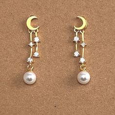 Dainty and lightweight earrings featuring a crescent moon with dangling stars and pearls. Delivered in a box ready for gifting or keeping. Metal: 18kt Gold plated over sterling silver Size: Length is 1 inch Celestial Woman, Woman Earrings, Stars Gold, Earrings Moon, Celestial Earrings, Moon And Star, Earrings Small, Lightweight Earrings, Moon Stars