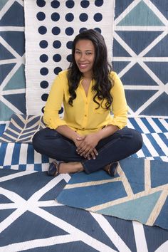 a woman sitting on top of a blue rug