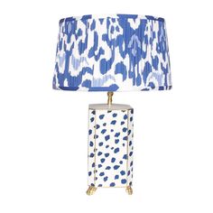 a blue and white lamp on a table with a shade over it's head