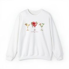 This chic and glam sweatshirt is perfect to wear during the holiday season. Three gorgeous Christmas cocktails and the words Holiday Cheer are printed on this cozy shirt.Long sleeve, crewneck sweatshirt. UNISEX SIZING: Please view size chart in the photos. These measurements are when shirt is laid flat.Available in sizes S - 2XL. Choose from several color choices.Ideal for any situation, a unisex heavy blend crewneck sweatshirt is pure comfort. These sweatshirts are a cotton/poly blend. The coll Casual Party Sweatshirt, White Crew Neck Sweater For Parties, Relaxed Fit Holiday Sweatshirt For Fall, Casual Long Sleeve Party Sweatshirt, Winter Party Sweatshirt With Crew Neck, Winter Party Crew Neck Sweatshirt, Casual Winter Party Sweatshirt, Casual Crew Neck Sweater For Party, Casual Holiday Sweatshirt With Graphic Print