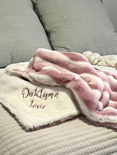 a blanket that is laying on top of a bed with pillows and blankets around it