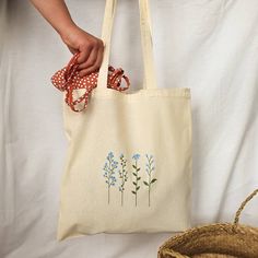 "Beautiful and elegant handpainted cottagecore blue tote bag. It's an ideal shopping bag, for your books and even a nice fashion bag for the whole year . In addition, it is very comfortable because of its long handles and many things fit :) 38 cm x 41 cm (14,96\" x 16,14\") The tote bags hold approximately 22.05 lbs (10 kg). I tell you how I painted it: First, I wash the cloth bag. This is how I get the final size of the bag (you will not be surprised when washing it because it already has its f Easy Tote Bag Design, Tote Bag Painting Ideas Flowers, Cute Tote Bag Design Paint, Flower Tote Bag Design, Tote Bag Diy Paint, Tote Bag Inspo Paint, Tote Bag Flower Design, Hand Painted Tote Bags Art, Tote Bag Painting Ideas Aesthetic