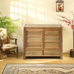 a living room with a rug, chair and wooden cabinet