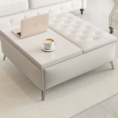 a coffee table with a laptop on it and a cup of coffee next to it