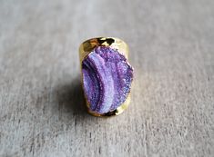 Super sparkly light purple druzy ring set on a hammered electroplated gold ban. SIZE : 7.5 Please avoid creams, soaps and water when wearing costume jewelry. For more rings please follow this link https://www.etsy.com/shop/mizzoktober?section_id=13858063 For shop policies please follow this link https://www.etsy.com/shop/mizzoktober/policy?ref=shopinfo_policies_leftnav Gold Amethyst Ring With Natural Stones As Gift, Gold Amethyst Ring Spiritual Gift, Adjustable Gold Amethyst Ring Gift, Gold Spiritual Amethyst Ring Gift, Spiritual Gold Amethyst Ring Gift, Handmade Gold Amethyst Ring Gift, Unique Gold Amethyst Ring For Gift, Hell Lila, Hammered Gold Ring