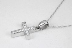 A token of faith. An 18k white gold cross showcases 11 stunning, princess cut diamonds, channel set. Each diamond is near colorless with 100% clean eye clarity. This pendant is a perfect size, not too small but big enough to be noticed and adored. This gorgeous diamond cross necklace is perfect for everyday use. It is an ideal gift to oneself or to someone you love! An inch 18K white gold cable chain is included with this diamond cross. Metal Purity: 18K White Gold (stamped behind bale: 18K) Set White Cross Pendant With Single Cut Diamonds, Cubic Zirconia Cross Diamond Necklace For Anniversary, Wedding Silver Cross Necklace With Cubic Zirconia, Formal Diamond Cross Necklace With Brilliant Cut, Luxury White Gold Cross Necklace For Formal Occasions, Anniversary Diamond Cross Necklace Vvs Clarity, Diamond Cross Necklace With Vvs Clarity For Anniversary, Diamond Pendant Cross Necklace For Anniversary, Anniversary Diamond Cross Necklace With Vvs Clarity