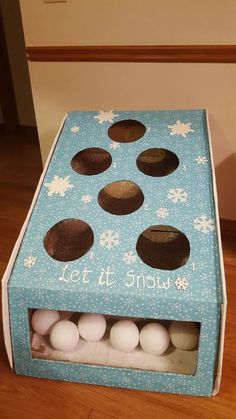 an open cardboard box with some balls in it