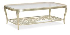 a glass and metal coffee table with an intricate design on the bottom, against a white background