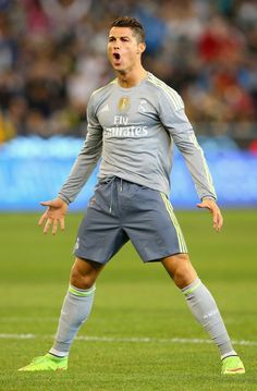 a man standing on top of a soccer field with his mouth open and hands in the air