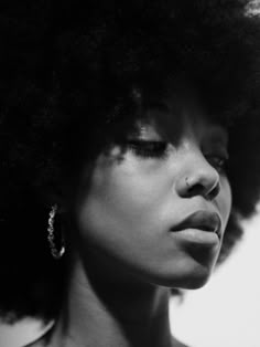 a black and white photo of a woman with an afro