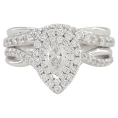 a white gold ring with diamonds on the band and a pear shaped diamond in the center