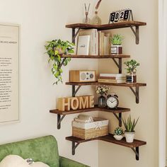 a living room with a green couch and some shelves filled with books, plants and other things