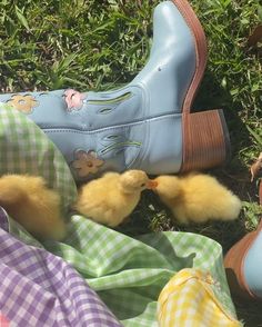 several different colored shoes and one yellow duckling are laying on the ground next to each other