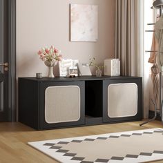 a living room with a black entertainment center next to a white rug and pink walls