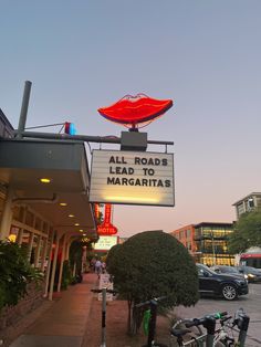 a sign that says all roads lead to margaritas with a red lips on it