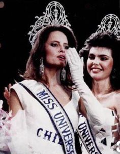 two beautiful women standing next to each other wearing crowns and tiaras on their heads