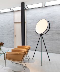 a living room filled with furniture next to a tall glass table and white tiled walls