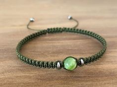 a green bracelet with two beads on it