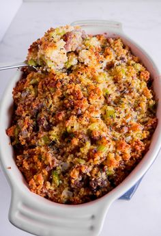 a casserole dish with broccoli and other toppings in a white bowl