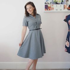 a woman standing next to a dress on a mannequin