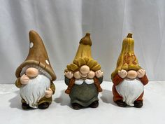 three gnome figurines sitting next to each other